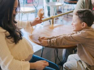 son offering ice cream to baby inside mom's belly