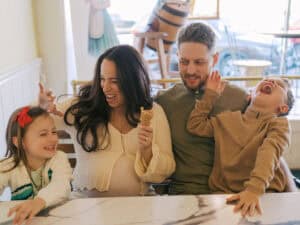 family laughing at ice cream parlor maternity photoshoot near Prosper, TX